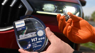 Auto Express products editor Tom Barnard fitting a Philips RacingVision GT200 bulb to a Skoda Superb 